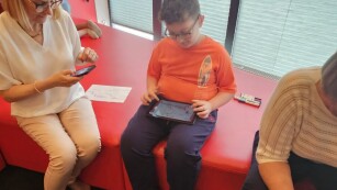 Uczeń korzysta z tabletu biblioteki, nauczycielka robi mu zdjęcie
