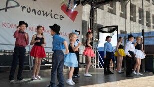 Dzieci w kolorowych ubraniach występują na scenie, tańcząc Lambadę